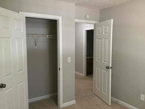 a bedroom with a closet and an open door to a closet