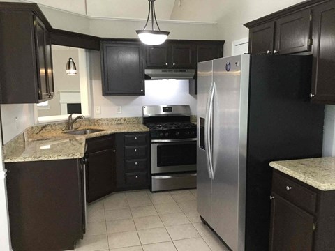 a kitchen with stainless steel appliances and black cabinets