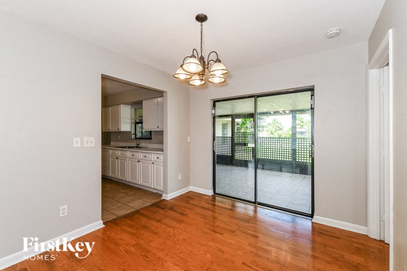 an empty living room with a sliding glass door to the kitchen