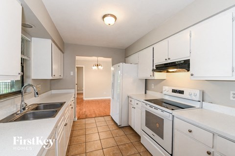 a kitchen with white cabinets and appliances and a sink