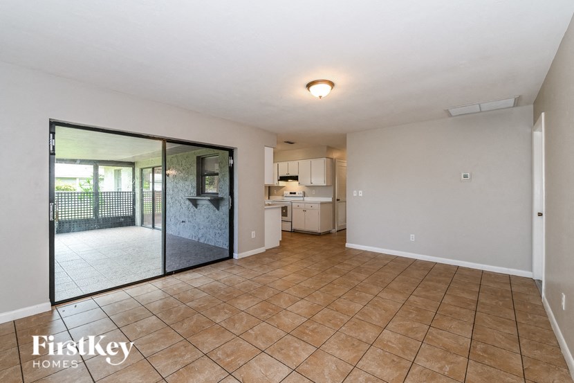 a spacious living room with a sliding glass door to the kitchen
