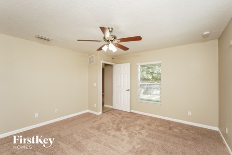 a living room with carpet and a ceiling fan