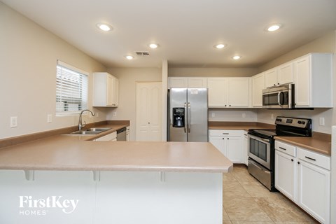 a large kitchen with white cabinets and stainless steel appliances
