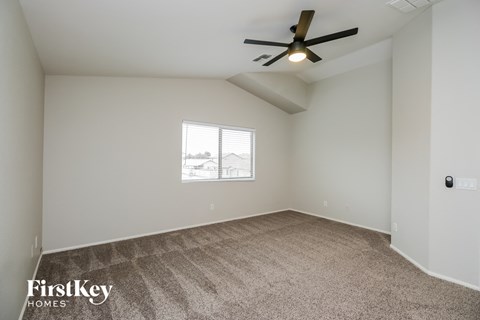 a living room with carpet and a ceiling fan