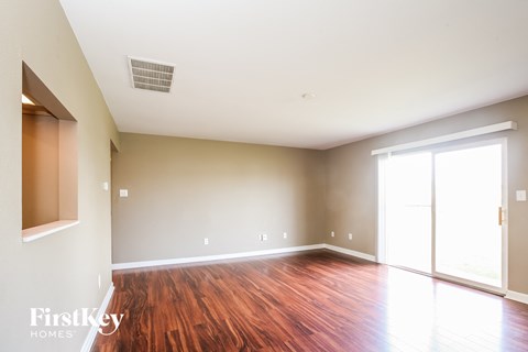 A room with wooden floors and a sliding glass door.