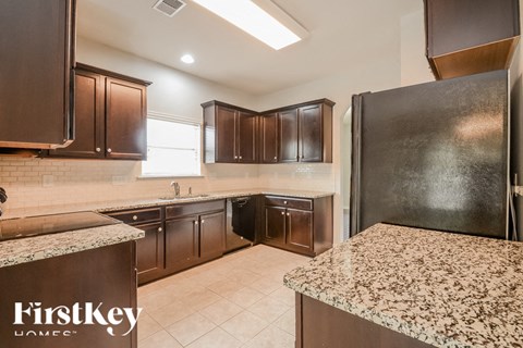 A kitchen with brown cabinets and a granite countertop.