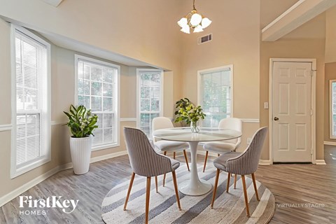 A dining room with a white table and chairs.