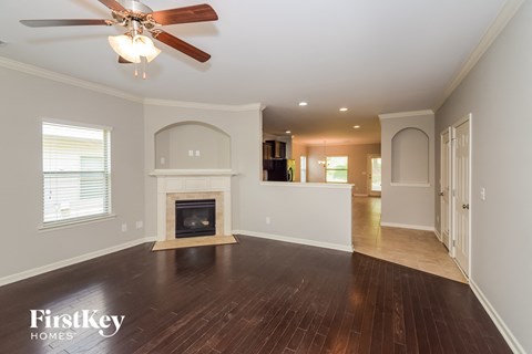 a living room with a fireplace and a ceiling fan