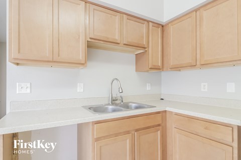 A kitchen with wooden cabinets and a white countertop.