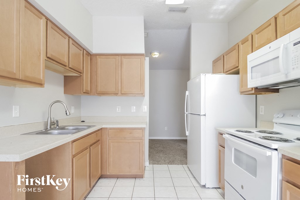 A kitchen with wooden cabinets and white appliances.
