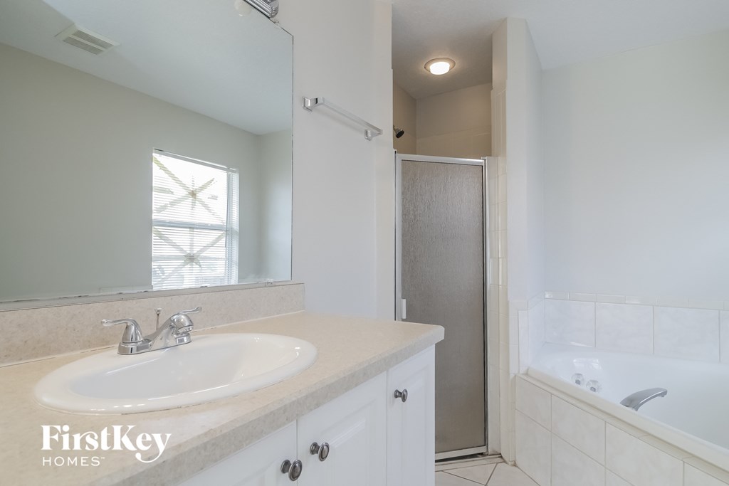 A bathroom with a white tub, sink, and toilet.