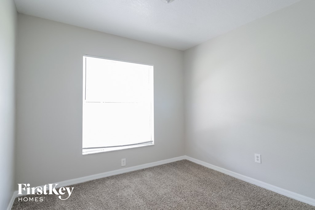 A room with a carpet floor and a window.