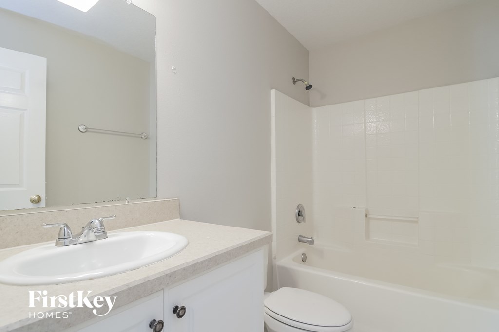 A white bathroom with a sink, toilet and bathtub.
