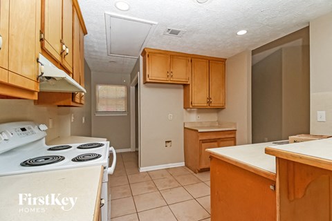 a kitchen with wooden cabinets and a stove top oven