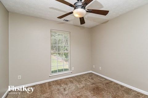a bedroom with a ceiling fan and a window