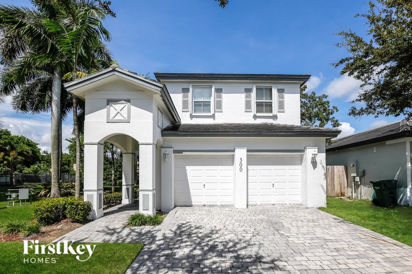 a white house with a white garage door and a driveway