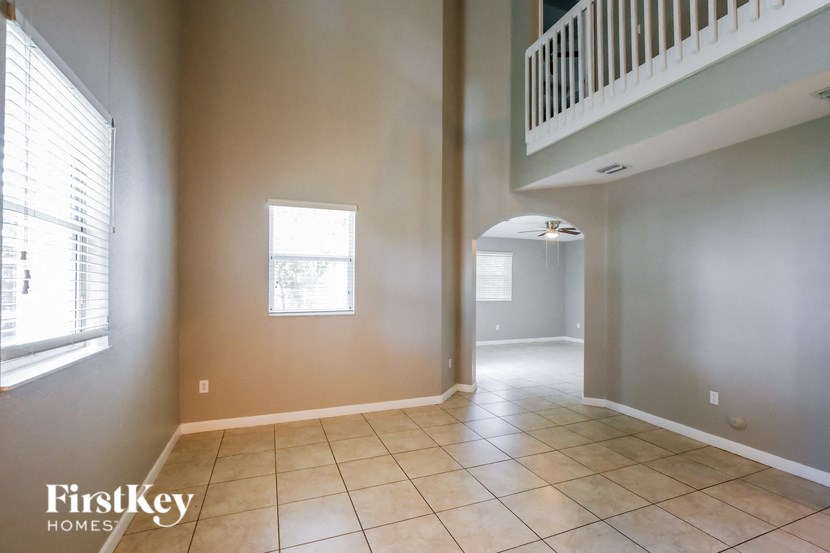 an empty living room and hallway with a staircase in a house