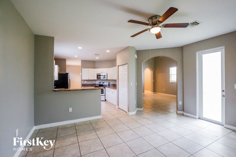 an empty kitchen and living room with a ceiling fan