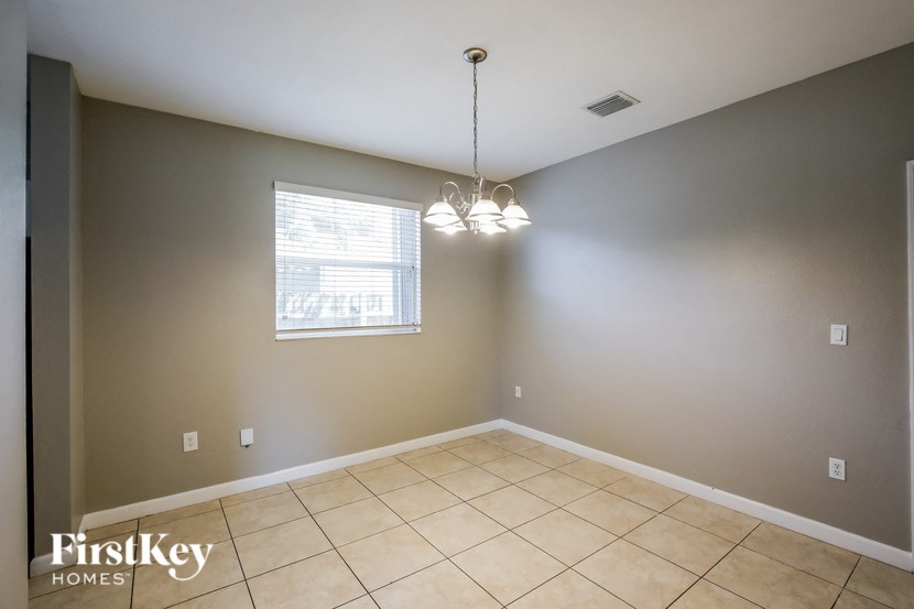 the living room of an empty home with tiled floors and a window