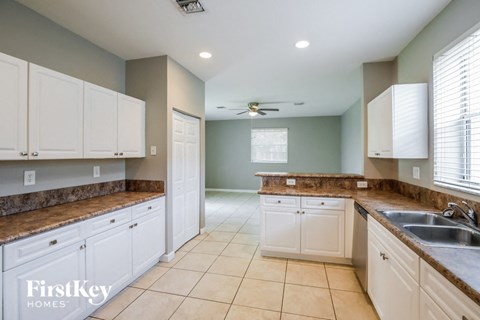 a large kitchen with white cabinets and granite counter tops