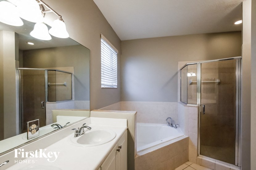 a bathroom with a sink and a shower and a tub