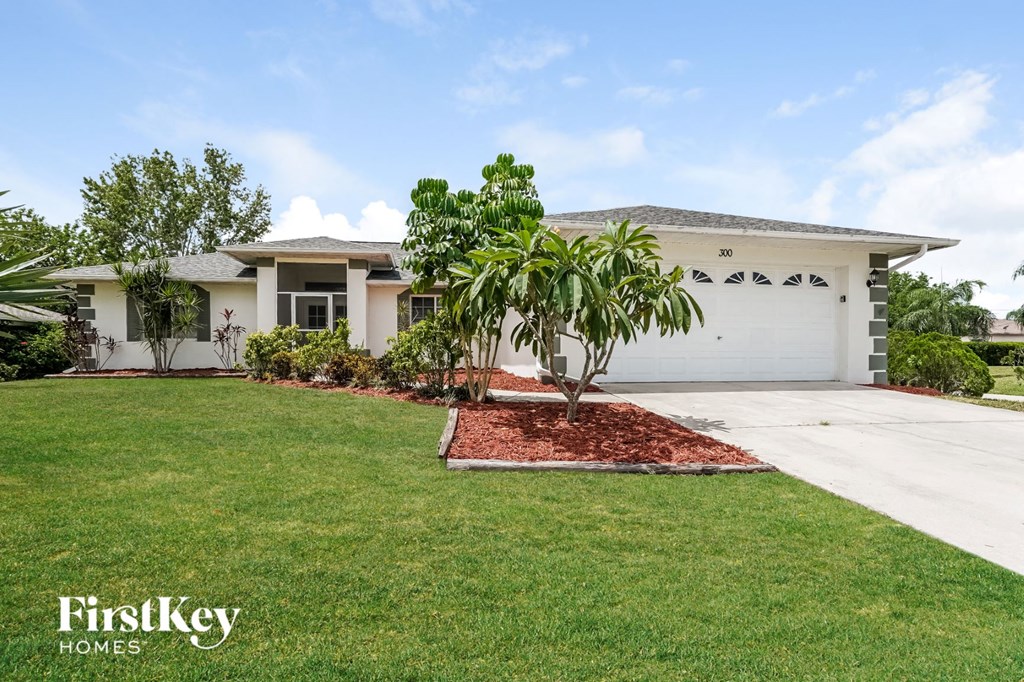 a house with a lawn and palm tree in front of it