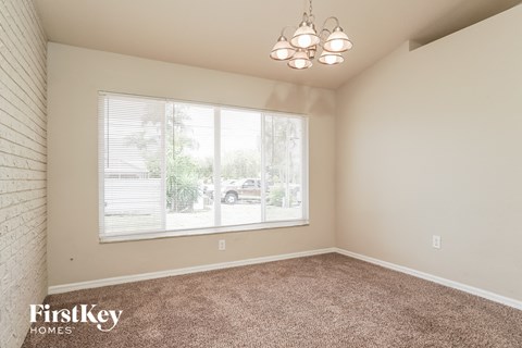 the living room of a home with carpet and a large window