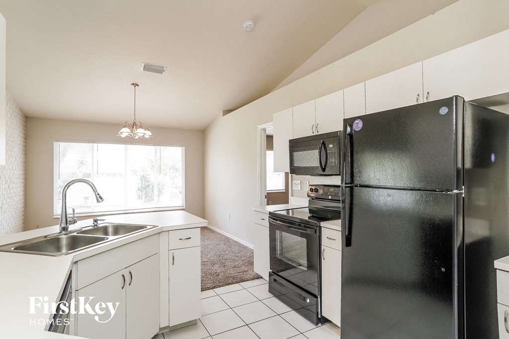 a kitchen with black appliances and white cabinets