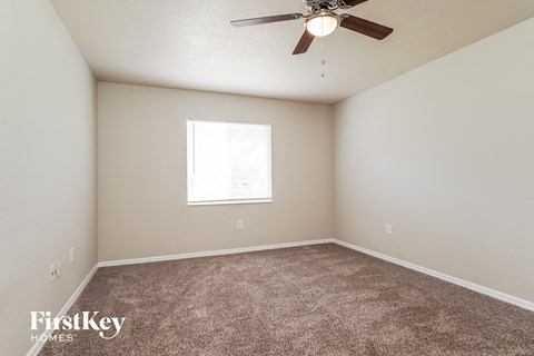 a bedroom with carpet and a ceiling fan