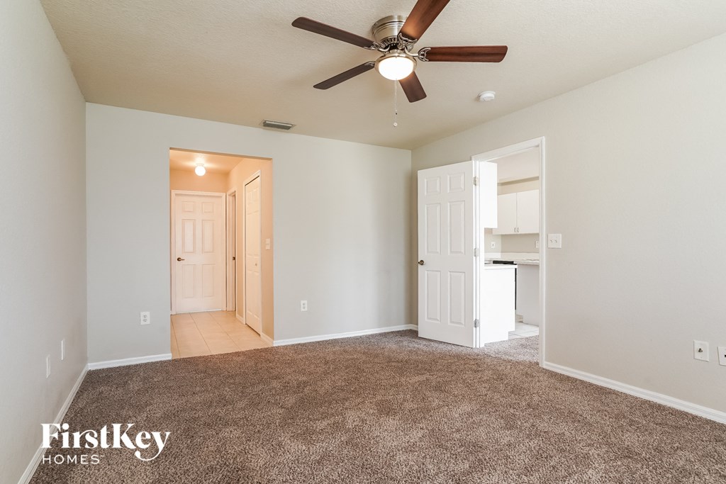 a living room with carpet and a ceiling fan