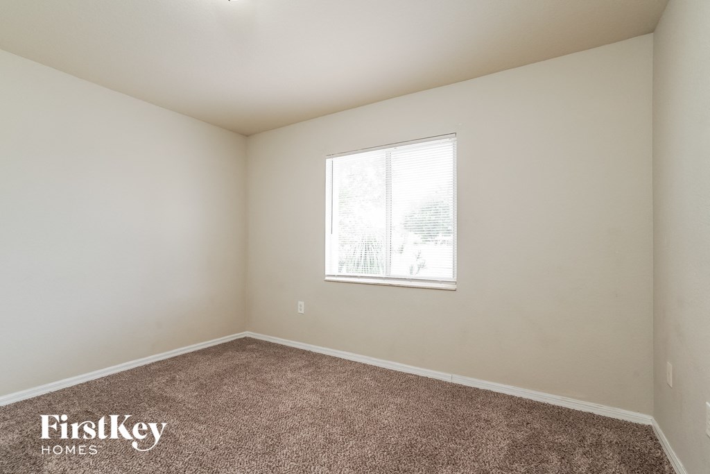 a bedroom with carpet and a window