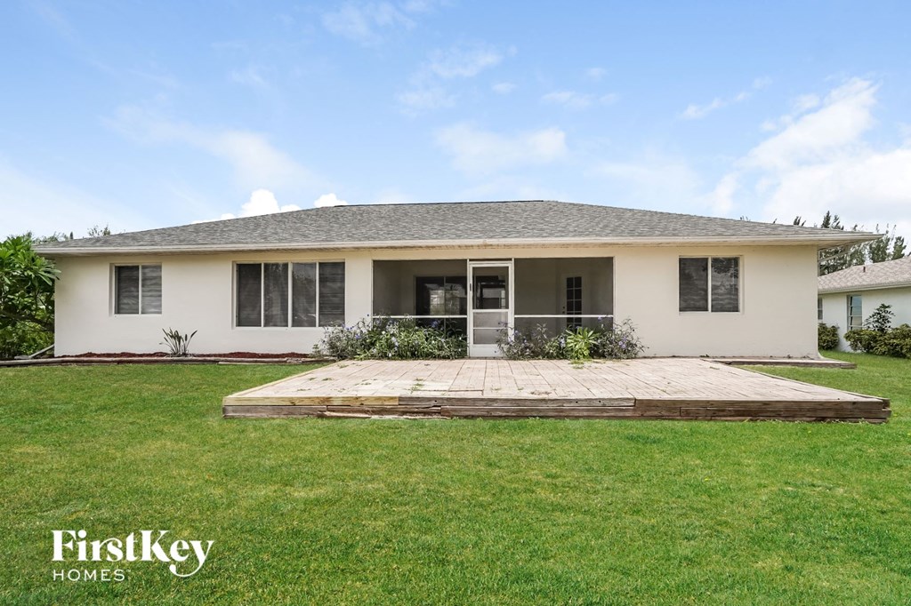 a house with a yard and a deck in front of it