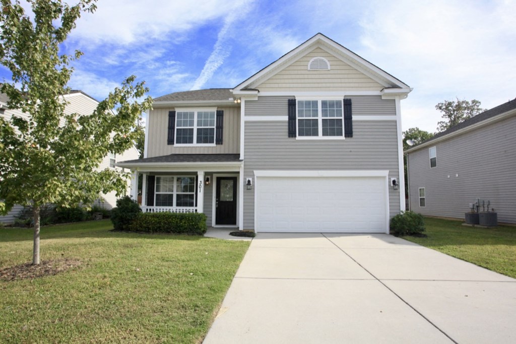 A two-story house with a garage and a driveway.
