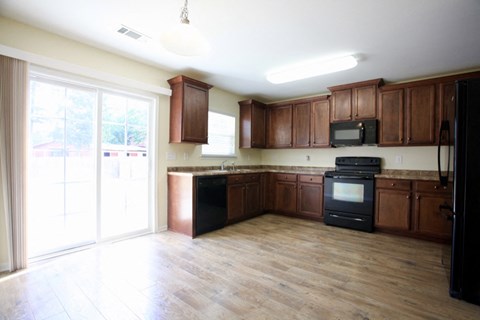 A kitchen with wooden cabinets and black appliances.