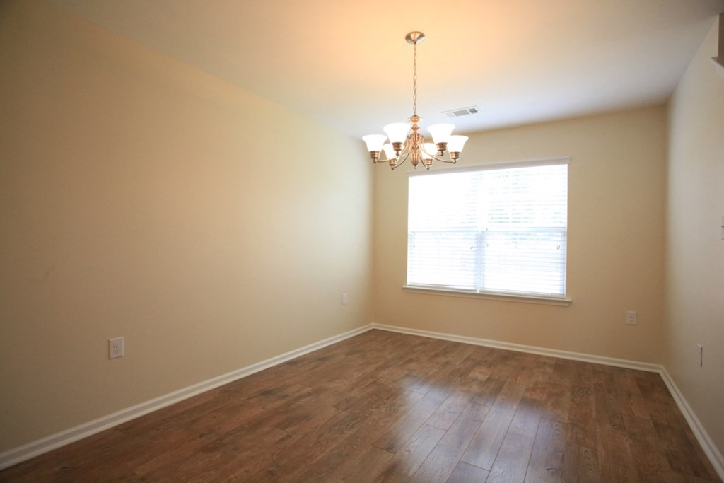 A room with wooden floors and a chandelier.