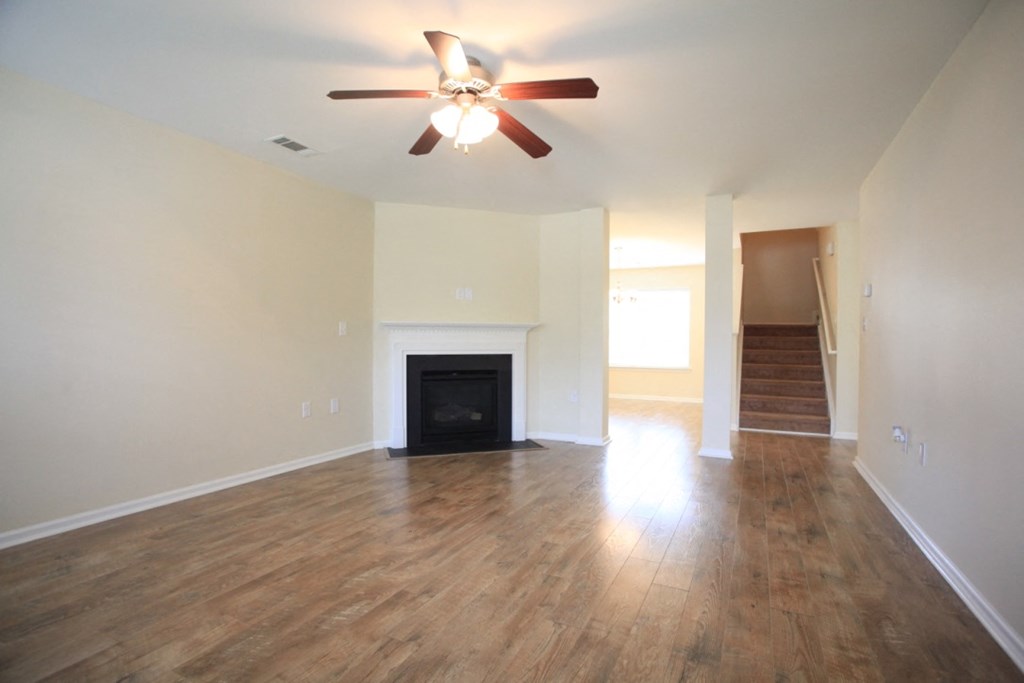 A room with a fireplace and a ceiling fan.