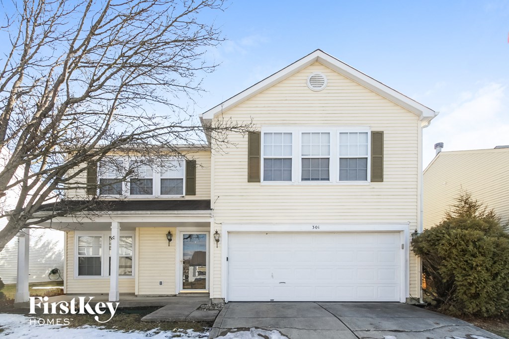 A two-story house with a garage is for sale.