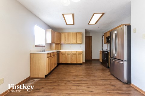 A kitchen with wooden cabinets and a stainless steel refrigerator.