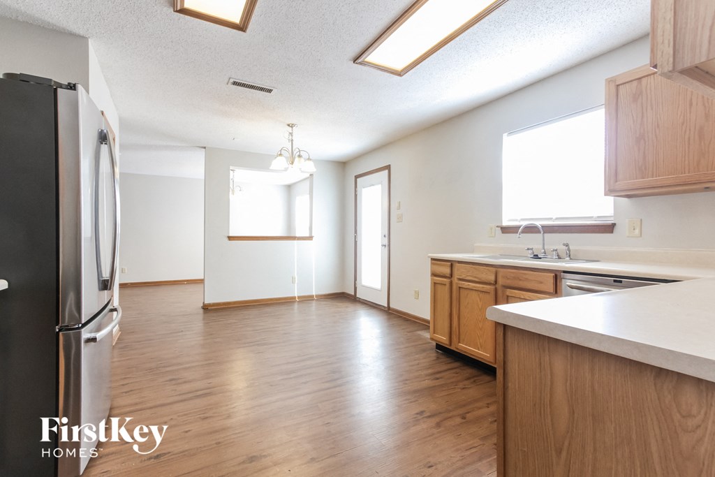 A kitchen with wooden floors and a refrigerator.