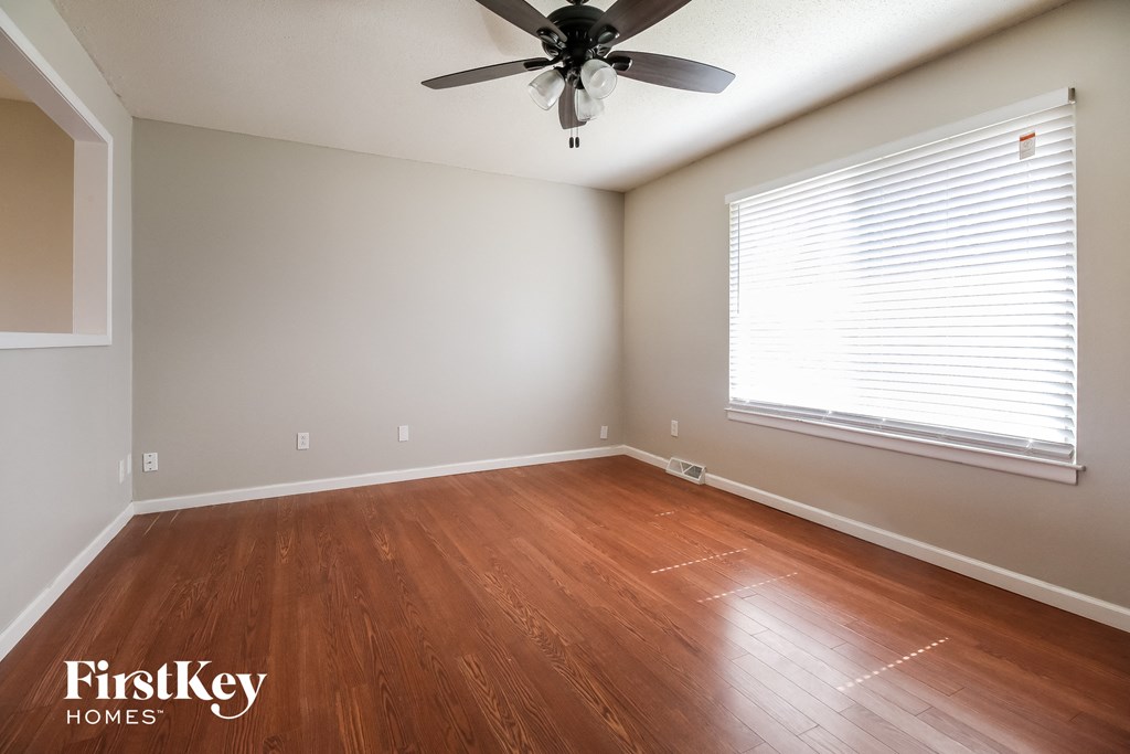 A room with wooden flooring and a ceiling fan.