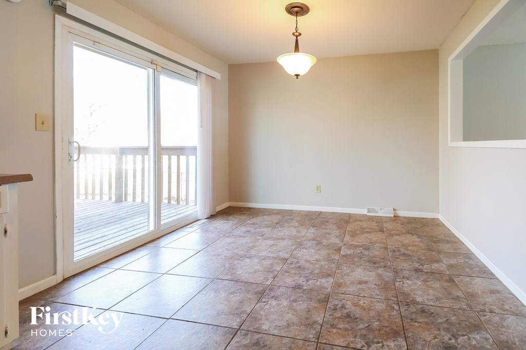 A room with a tiled floor and a sliding glass door leading to a balcony.