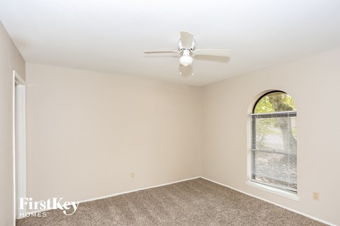 a bedroom with a ceiling fan and a window