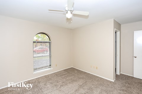 a living room with carpet and a ceiling fan