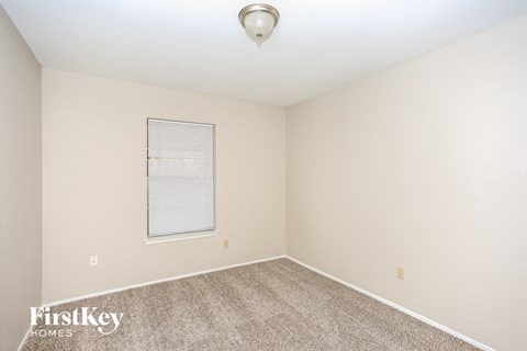 a spacious room with carpet and a window