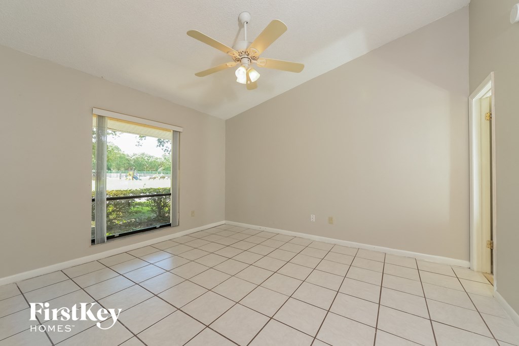 an empty living room with a ceiling fan