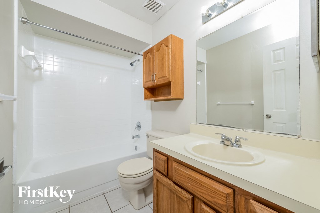a bathroom with a sink toilet and shower and a mirror