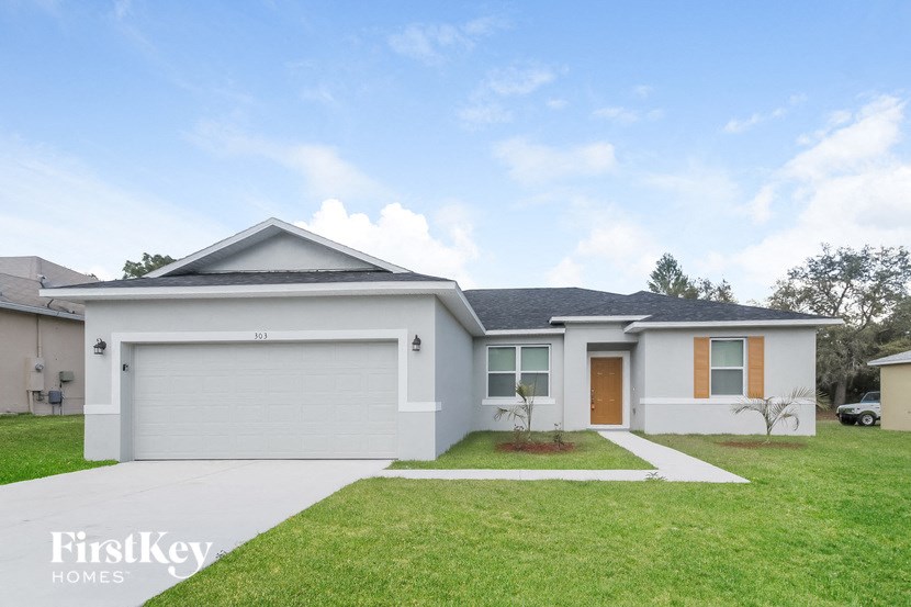 a white house with a lawn and a driveway