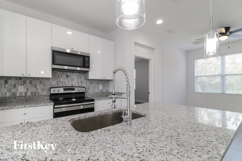 a white kitchen with a sink and a stove