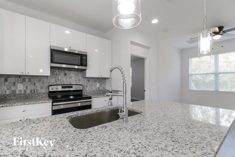 a white kitchen with a sink and a stove