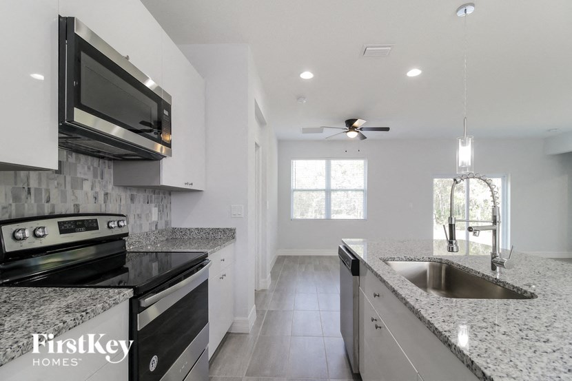 a modern kitchen with granite counter tops and black and white appliances